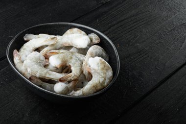 Donmuş çiğ kaplan karidesleri, karidesler, siyah ahşap arka planda, metin için kopyalama alanı