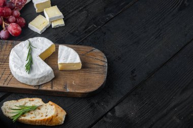 Farm cheese camembert seti, siyah ahşap masa ve metin için fotokopi alanı.
