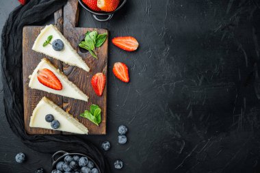 New York cheesecake ya da taze berrie ile klasik cheesecake, siyah arka planda, üst görünüm düz metin alanı ile yatıyordu