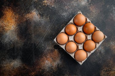 Yumurta kutusu seti içinde tavuk yumurtaları, eski koyu kırsal arka planda, üst görünüm düz, metin kopyalanacak yeri var.