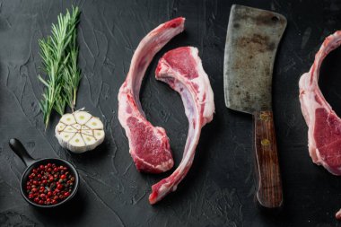 Çiğ kuzu pirzola seti, siyah taş arka planda, havuç portakalı, otlar...