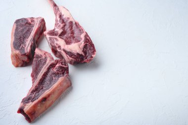 Çeşitli klasik, alternatif çiğ et, dana bifteği, kuru yaş seti, tomahawk, kemik ya da biftek seti beyaz taş arka planda, metin için kopyalama alanı olan kulüp bifteği.