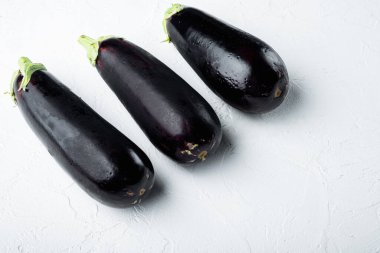 Sağlıklı ve lezzetli mor patlıcan seti, beyaz taş zemin üzerinde, metin için kopyalama alanı ile