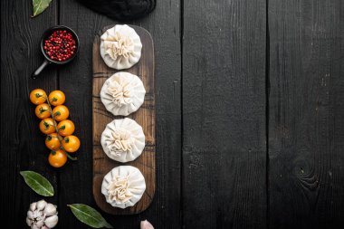 Donmuş çiğ hamur köfteleri Khinkali sığır eti ve kuzu eti seti, siyah ahşap masa arkaplanı, üst görünüm düz, metin için kopyalama alanı ile