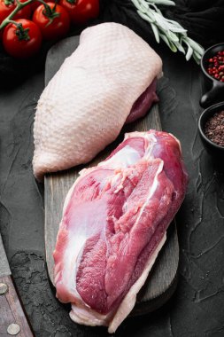 Çiğ ördek göğsü, derisi yüzülmüş, siyah taş arka planda.
