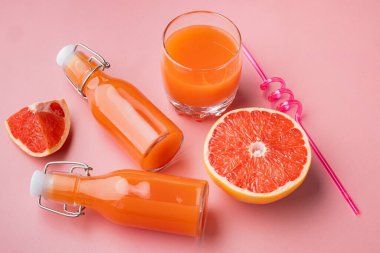 Pembe desenli yaz arkaplanındaki greyfurt suyu seti.