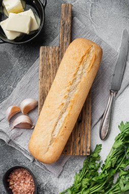 Sarımsak ve gerbanlar için malzemeler ekmek baget seti, gri taş masa arkaplanı, üst görünüm düz yatıyordu