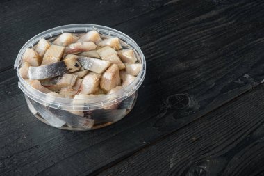 Yağda salamura Hollanda filetosu, siyah ahşap masa zemininde metin için kopya alanı ile.