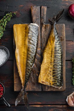 Tütsülenmiş balık uskumrusu, eski koyu ahşap masa zemininde, üst manzara düz yatıyordu.