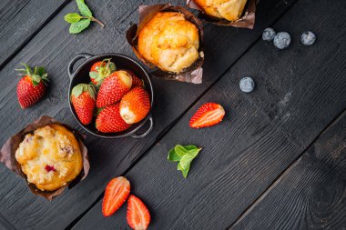 Yaban mersinli kek, siyah ahşap masa arkaplanı, üst görünüm düz metin alanı için fotokopi alanı ile yatar