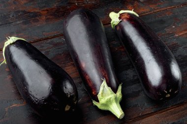 Taze çiğ Mor Patlıcan seti, eski, siyah ahşap masa arka planında.