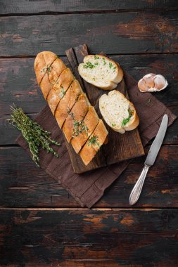 Sarımsak ve bitkilerle kızartılmış ekmek, eski koyu ahşap masa arkaplanı, üst görünüm düz, metin alanı için kopyalama alanı ile