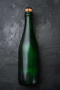 Yeşil şarap şişesi seti, siyah taş masa arkaplanı, üst manzara düz yatıyordu.