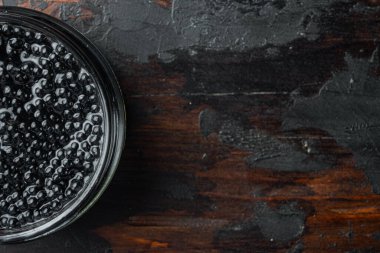 Siyah havyar kavanozu, eski koyu ahşap masa arkaplanı, üst görünüm düz metin alanı için fotokopi alanı ile yatıyordu