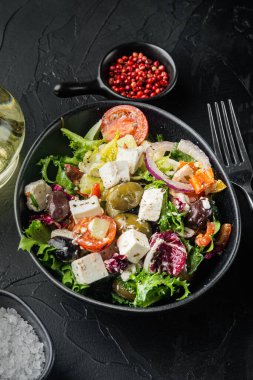 Siyah arkaplanda domates, zeytin ve peynir ile Yunan salatası