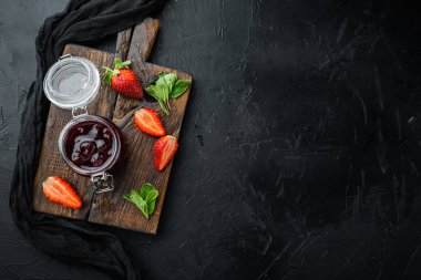 Çilek reçeli kavanozları, böğürtlenli, siyah arkaplanlı, üst görünüm düz metin alanı için fotokopi alanı