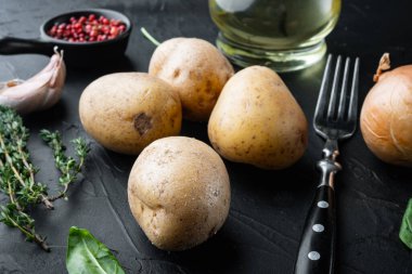 Siyah arka planda taze patates yığını.