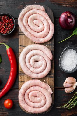 Çiğ et sosisi seti, eski koyu ahşap masa arkaplanı, üst görünüm düz yatıyordu