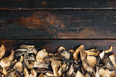 Kurumuş mantarlar seti, eski koyu ahşap masa arkaplanı, üst görünüm düz yatay, metin kopyalama alanı için boşluk