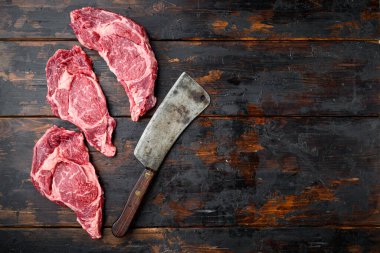Taze ve çiğ et, eski kasap bıçağı ile tüm parça, koyu ahşap arka planda, kaburga kesimi, üst düz görünüm, metin için metin alanı ile
