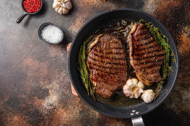 Tavada ızgara Picanha organik biftek, otlar ve sarımsak. Eski koyu metal arkaplan üzerinde, metin için boşluk ile üst görünüm