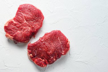 Kalça bifteği, çiftlik organik çiğ eti, beyaz desenli arka plan. Metin için üst görünüm alanı