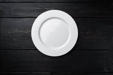 Metin veya yiyecek için kopyalama alanı olan beyaz tabak boş çatal bıçak seti, üst görünüm düz, siyah ahşap masa arkaplanı