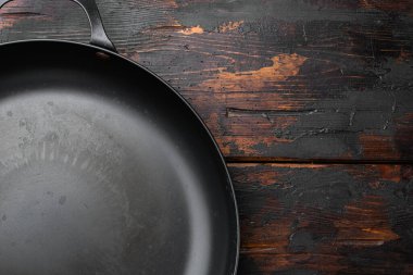 Metin veya yiyecek için kopyalama alanı olan eski boş tava seti, üst görünüm düz, eski koyu ahşap masa arkaplanı üzerinde