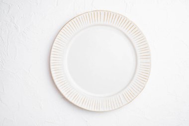 Metin ya da yiyecek için kopyalama alanı olan beyaz tabak boş çatal bıçak seti, beyaz taş masa arka planında düz görünüm yatağı