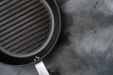 Metin ya da yiyecek için kopyalama alanı olan boş ızgara tavası seti, üst görünüm düzlüğü, gri taş masa arkaplanı