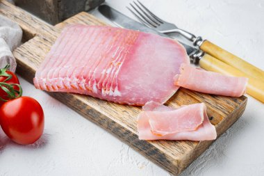 Beyaz taş zemin üzerinde, şifalı bitkiler ve malzemelerle hazırlanmış domuz eti ya da prosciutto.