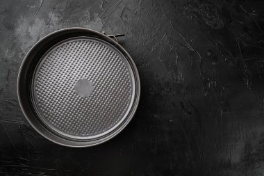 Metal boş fırın tepsisi seti, metin veya yiyecek için kopyalama alanı, metin veya yiyecek için kopyalama alanı, üst görünüm düz, siyah koyu taş masa arkaplanı üzerinde