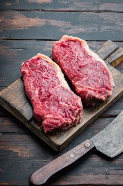 Strip loin biftek, çiğ mermer et, eski ahşap masa üzerinde, metin için fotokopi alanı ile