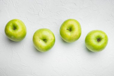 Beyaz taş masa arka planında, birkaç olgun yeşil elma seti, üst görünüm düz yatıyordu