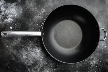 Wok pan boş seti metin ya da yiyecek için metin ya da yiyecek kopyalama alanı ile, üst görünüm düz, siyah taş masa arkaplanı üzerinde