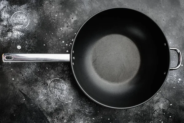 Wok pan empty set with copy space for text or food with copy space for text or food, top view flat lay, on black dark stone table background