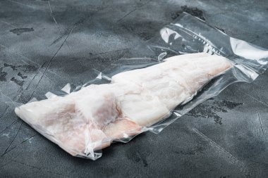 Mezgit balığı filetosu plastik pazar paketinde, gri zemin üzerinde metin için kopyalama alanı ile birlikte