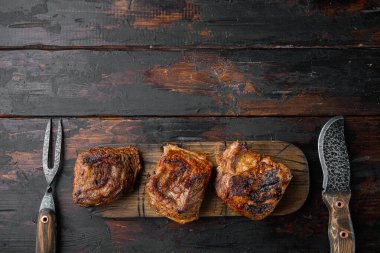 Lezzetli ağır ateşte pişmiş sığır kaburga seti, eski koyu ahşap masa arkaplanı, üst görünüm düz, metin için kopyalama alanı ile