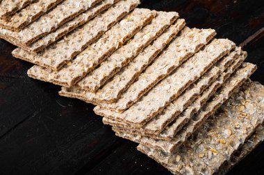 Tahıl diyeti hafif gevrek ekmek seti, eski siyah ahşap masa arka planında