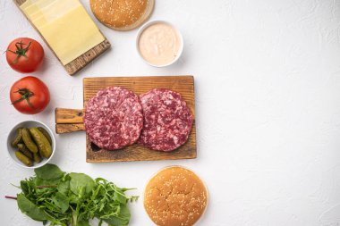Çiğ kıymalı biftek köfteleri ve hamburgerli baharatlar, beyaz taş zemin üzerinde, düz görünüm yatağı, metin için fotokopi alanı