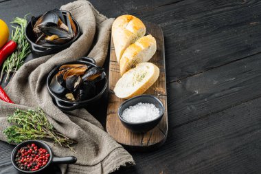 Kaynamış midyeler maydanoz, baharat ve ekmek seti, siyah ahşap masa zemininde, metin alanı ve yeri olan.