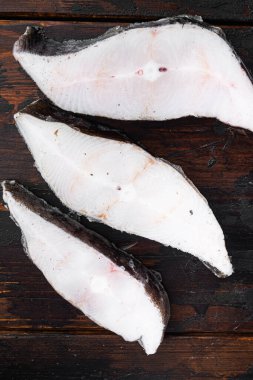 Donmuş balık bifteği seti, eski koyu ahşap masa arkaplanı, üst manzara düz yatıyordu