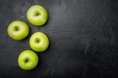 Olgun yeşil elma seti, siyah taştan masa arkaplanı, üst görünüm düz yatay, metin için kopyalama alanı