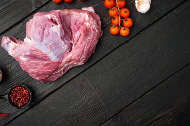 Çiğ İber domuzu dilimi, malzeme seti, siyah ahşap masa arkaplanı, üst görünüm düz, metin alanı için fotokopi alanı
