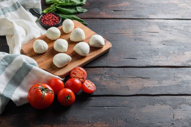 Mozzarella peyniri, fesleğen domates kirazı eski ahşap masa üzerinde metin için seçici odak alanı.