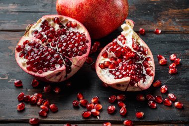 Olgun nar ve sulu tohumlar, eski ahşap masanın üzerinde.