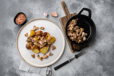 Gri taş masa arkaplanının üzerinde Chanterelles soslu patatesler yatıyordu.