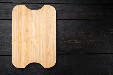 Bambu kesme tahtası boş metin ya da yiyecek kopyalama alanı için boş, üst görünüm düz, siyah ahşap masa arkaplanı üzerinde