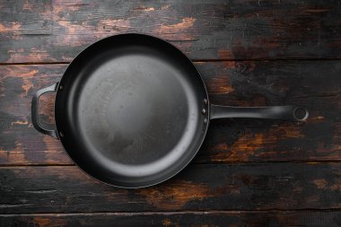 Metin veya yiyecek için kopyalama alanı olan demir kızartma tavası seti, üst görünüm düz, eski koyu ahşap masa arkaplanı