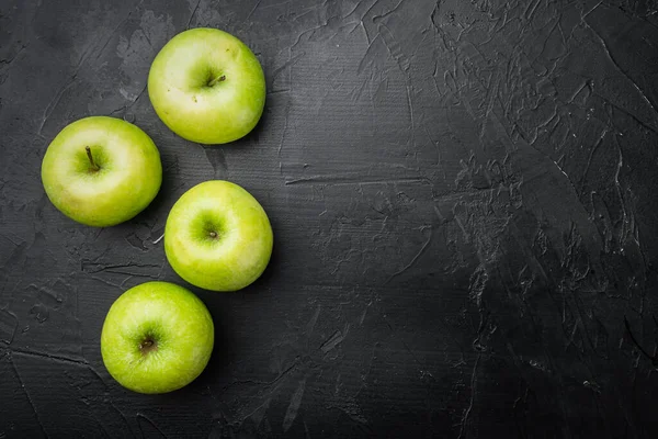 Olgun yeşil elma seti, siyah taştan masa arkaplanı, üst görünüm düz yatay, metin için kopyalama alanı